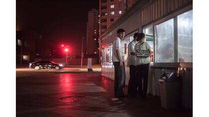 Unas personas hacen cola en un puesto de bocadillos en Pyongyang
