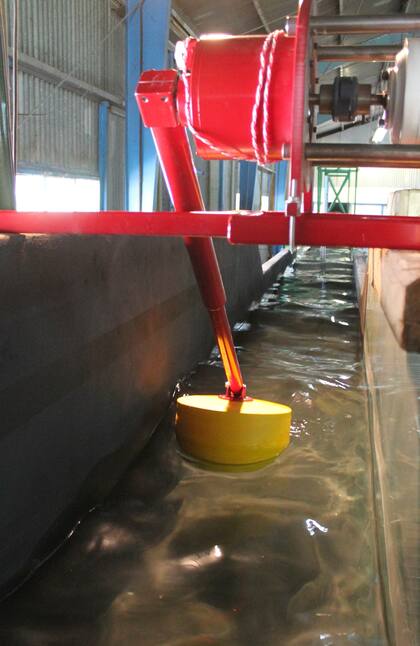 El movimiento vertical que genera la onda de una ola (el momento antes de que rompa en la orilla) mueve el brazo de una palanca que está acoplado de manera fija a la boya amarilla