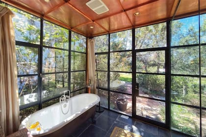 Uno de los baños, con vista al parque. La propiedad es de 1200 metros cubiertos y, además del edificio principal, tiene una casa de huéspedes con su propia cocina y un estudio de pintura que usaba Hackman, un artista plástico amateur