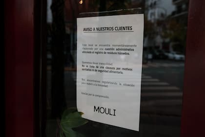 Uno de los bares que fue clausurado y el cartel que colocaron en la puerta