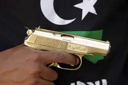 Uno de los combatientes del CNT exhibe un arma que supuestamente perteneció a Muammar Khadafy