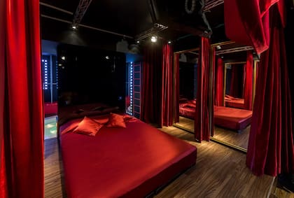 Uno de los cuartos tiene la cama sobre una especie de escenario, que incluso tiene un telón rojo