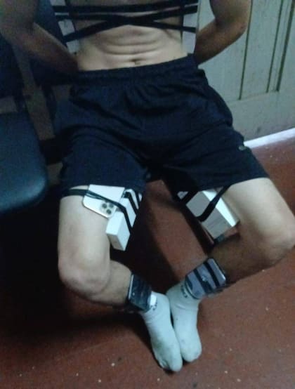 Uno de los delincuentes con los celulares pegados en su cuerpo cuando intentaba escapar