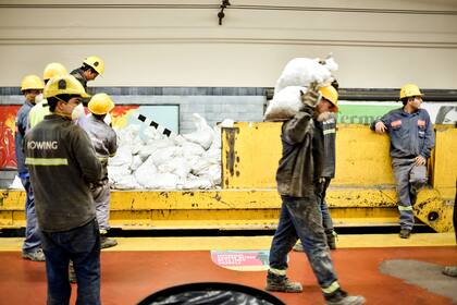 Uno de los dos trenes que ingresan a los túneles está cargado con bolsas de grava, o piedra, que se distribuyen a lo largo de la traza