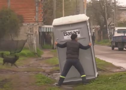 Uno de los empleados de la empresa de baños químicos acomoda las unidades de forma manual