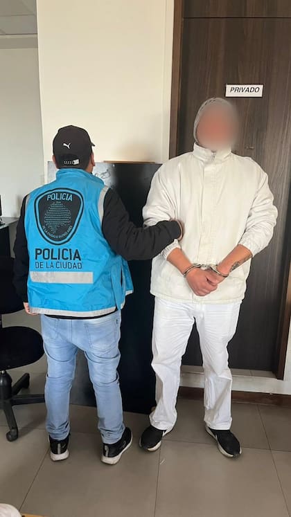 Uno de los empleados detenidos es escoltado por la Policía de la Ciudad en el interior del establecimiento industrial