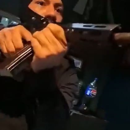 Uno de los integrantes del grupo comando apunta a la mujer