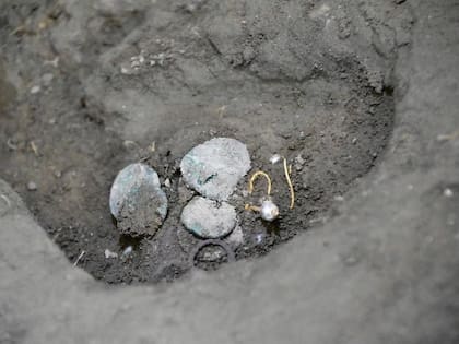 Uno de los pendientes de oro con una perla que se halló cerca del esqueleto de la mujer