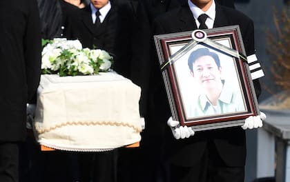Uno de los presentes en el funeral cargó un retrato de Sun-kyun mientras los portadores del féretro llevaban su ataúd

