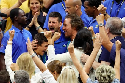 Uno más de la familia serbia: Djokovic celebra su nuevo título con Matthew McConaughey, sentado en el palco de su familia, una fila más adelante que Srdjan y Dijana, los padres del deportista