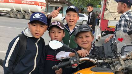 Unos niños se acercan a admirar la moto de Manuel Lastra en Turkmenistán