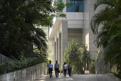 Unos oficinistas salen de un complejo de oficinas que alberga las oficinas y el estudio de la BBC en Bombay el 14 de febrero de 2023.