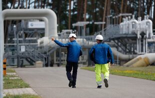 Unos trabajadores pasan por delante de las instalaciones de recepción y distribución de gas natural en los terrenos del operador de redes de transporte y gasoductos Gascade en Lubmin, al noreste de Alemania