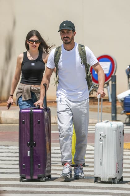 Úrsula Corberó y el Chino Darín llegando a Ibiza para el casamiento de unos amigos. Mientras ella usó gafas negras para despistar a los paparazzis, él acudió al recurso de la gorrita
