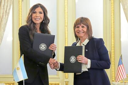 U.S. Homeland Security Secretary Kristi Noem, left, and Argentina's Minister of National Security Patricia Bullrich shake hands for the camera as they hold bilateral agreements at the presidential palace in Buenos Aires, Argentina, Monday, July 28, 2025. (AP Photo/Alex Brandon, Pool)