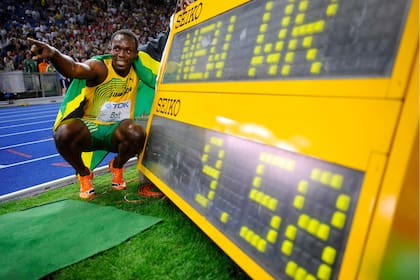 Usain Bolt sonríe junto a el histórico récord mundial que estableció para los 100 metros en Berlin 2009