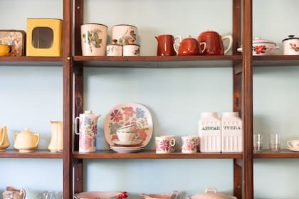 Vajilla antigua exhibida en los estantes de la cafetería