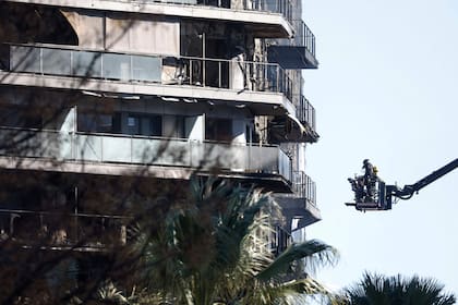 Los bomberos inspeccionan las secuelas de un gran incendio que ayer arrasó un bloque residencial de varias plantas matando al menos a cuatro personas, en Valencia el 23 de febrero de 2024