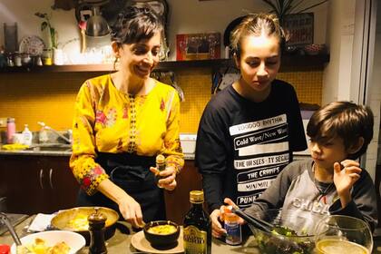 Valeria y sus hijos Ema y Moro, preparando la cena