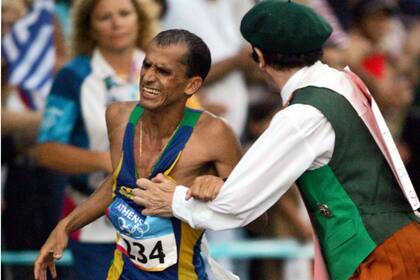 Vanderlei de Lima en el momento en que el sacerdote irlandés Corneluis Horan lo saca de carrera