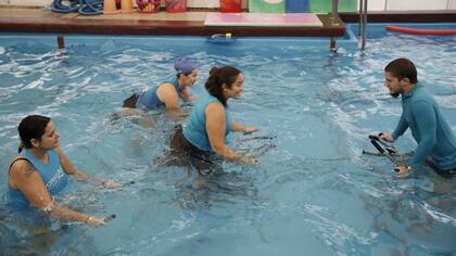 Vanina Delfino (centro) coordina una clase de ciclismo estacionario acuático