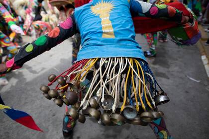 Varias campanas cuelgan de una persona que baila con un disfraz de diablo para celebrar la festividad católica del Corpus Christi