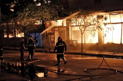 Varias dotaciones de bomberos trabajaron para apagar el incendio que se propagó a casas y edificios vecinos