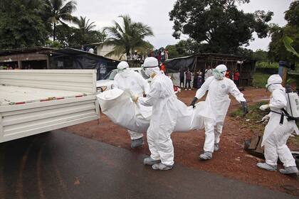 Varias enfermeras liberianas trasladan a una víctima del ébola en Virginia, en las afueras de Monrovia, en Liberia