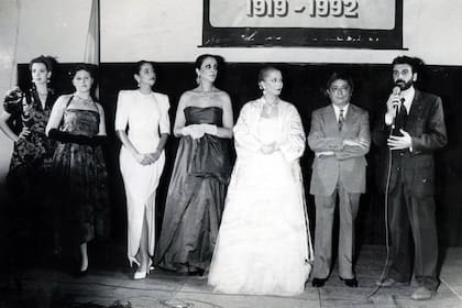 Varias modelos lucen vestidos que pertenecieron a Eva Perón junto al diseñador de los mismos, Paco Jamandreu