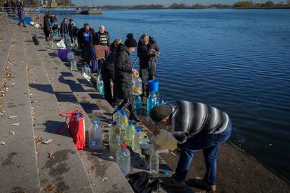 Varias personas colectan agua del río Dniéper en Kherson, Ucrania, el 15 de noviembre de 2022. 