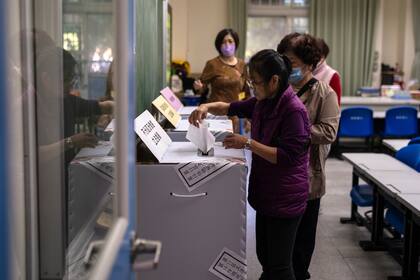 Varias personas depositan su voto en una casilla electoral durante las elecciones el sábado 13 de enero de 2024, en Nueva Taipéi, Taiwán. (AP Foto/Louise Delmotte)