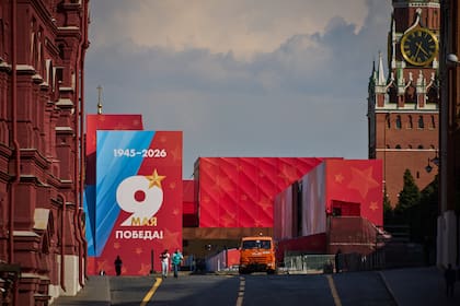Varias personas pasan por delante de un cartel del Día de la Victoria, en una entrada cerrada a la Plaza Roja, decorada para la celebración del 81er aniversario de la victoria de la Unión Soviética sobre la Alemania nazi en la Segunda Guerra Mundial, en Moscú, Rusia, el 6 de mayo de 2026.