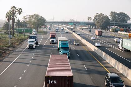 Varios camiones avanzan sobre la Interstate 710 en Long Beach, California, cerca del puerto de Los Angeles