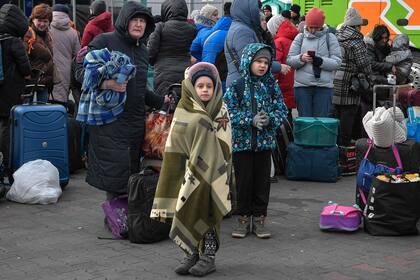 Varios niños esperan tomar un micro en un antiguo centro comercial entre la frontera con Ucrania y la ciudad polaca de Przemysl, en Polonia