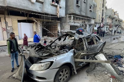 Varios observadores comprueban el auto en el que, al parecer, murieron tres hijos del líder de Hamas, Ismail Haniyeh, en un ataque aéreo israelí en el campo de Al Shati, al oeste de la ciudad de Gaza, el 10 de abril de 2024.