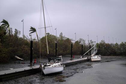 Varios veleros yacen en el fondo del puerto de Charlotte durante una retirada de la marea cuando el ojo del huracán Ian pasó por Punta Gorda