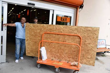 Vecinos de Orlando se aprovisionan de maderas para tapiar sus casas