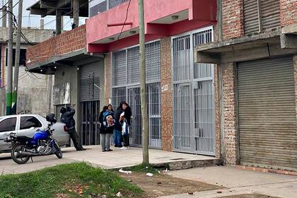 Vecinos esperan para comprar en la carnicería ubicada a pocos metros del supermercado chino atacado anoche.