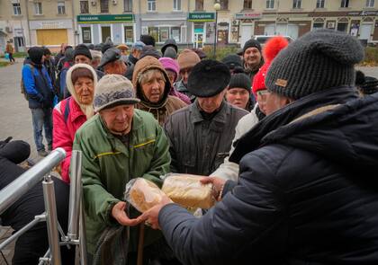 Vecinos hacen fila para recibir pan gratis repartido por voluntarios en Bakhmut, uno de los lugares con combates más fuertes contras las tropas rusas en la región de Donetsk, Ucrania, el viernes 28 de octubre de 2022. (AP Foto/Efrem Lukatsky, Archivo)