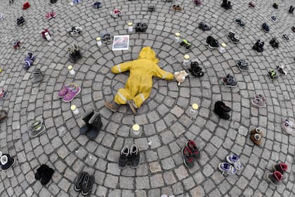  Velas, ropa y zapatos de niños se ven durante una manifestación organizada por la Asociación Ucraniana en Finlandia, para honrar la memoria de los niños asesinados en Mariupol, Ucrania, en Helsinki, el 10 de abril de 2022.