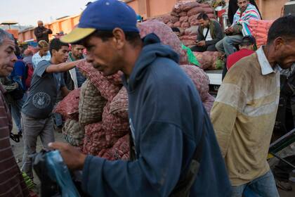 Venezolanos transportan verduras para los clientes en un mercado mayorista de alimentos en Caracas, Venezuela, el 28 de enero. según economistas, cuanto más se prolonga el enfrentamiento entre el líder de la oposición respaldado por Estados Unidos, Juan Guaidó y el presidente Nicolás Maduro, más pro