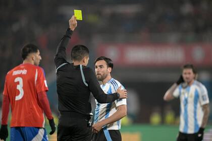 El árbitro venezolano Jesús Valenzuela muestra una tarjeta amarilla al defensor argentino Nicolás Tagliafico durante el partido de fútbol de las eliminatorias sudamericanas de la Copa Mundial de la FIFA 2026 entre Chile y Argentina