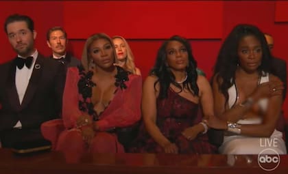 Venus Williams (izquierda de la imagen), escucha atentamente el discurso de Will Smith sin darse cuenta de que su vestido deja ver más de lo debido