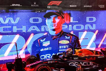 Verstappen sale de su auto luego de la carrera sprint en Lusail; la pantalla lo celebra como tricampeón mundial de Fórmula 1.