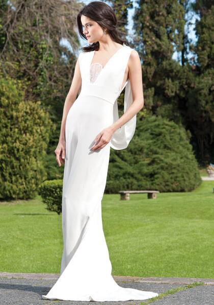 Vestido columna con suave cola en crêpe de seda natural con detalle de encaje en el escote y en la espalda, más foulard en crêpe de seda natural que nace en los hombros.