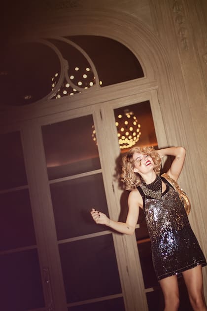 Vestido de lentejuelas en plata y oro (Paula Cahen dAnvers), riñonera de cuero metalizado (Las Pepas).