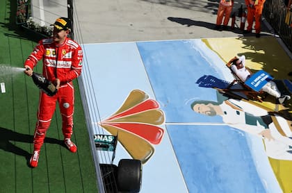 Vettel festeja su triunfo y abajo, Fernando Alonso recrea la imagen de un momento icónico de la Fórmula 1