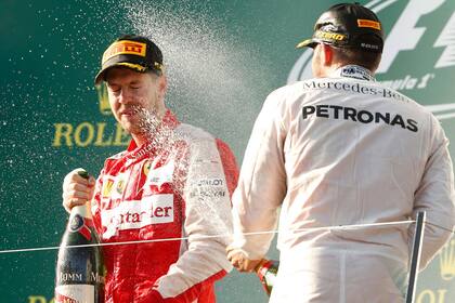 Vettel se subió al podio; aquí, el festejo con Hamilton