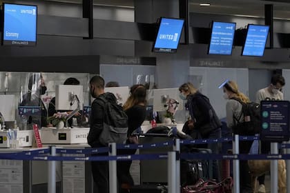 Viajeros con máscaras faciales se registran en los mostradores en el Aeropuerto Internacional de San Francisco durante el brote de coronavirus en San Francisco, el martes 24 de noviembre de 2020