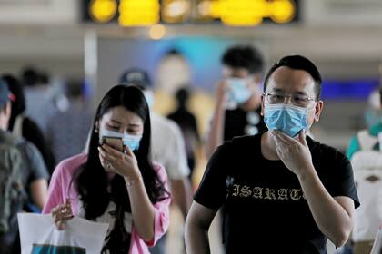 Viajeros en Sri Lanka llevan barbijos para evitar el contagio con el coronavirus, que ya suma 26 muertos en todo el mundo